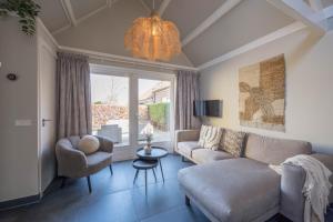 a living room with a couch and chairs and a chandelier at De Grote Stern in Groet