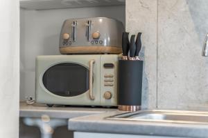 a microwave sitting on top of a kitchen counter at 2 Bedroom flat for Corporate, workers, Relocation, West st in Buckinghamshire