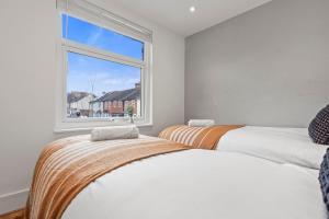 two beds in a room with a window at 2 Bedroom flat for Corporate, workers, Relocation, West st in Buckinghamshire