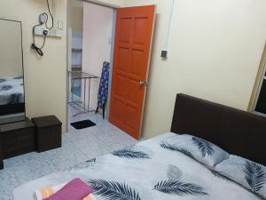 a bedroom with a bed and a red door at Qc HOMESTAY JINTAN- Bukan Islam Pemilik in Pasir Mas