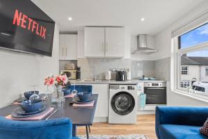 a kitchen with a table and blue chairs at 2 Bedroom flat for Corporate, workers, Relocation, West st in Buckinghamshire +30 photos