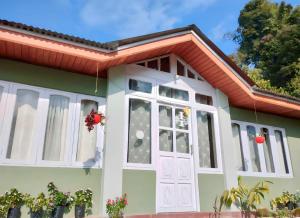 a small green house with a white door at ARITER HOMESTAY monikung mountain inn in Aritar