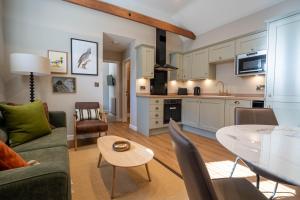 une cuisine et un salon avec un canapé et une table dans l'établissement Dunes Cottage, à Lowestoft