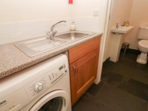 a kitchen with a sink and a washing machine at No 3 The Hinges in Newquay +24 photos