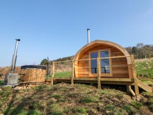 a wooden hobbit house on a hill in a field at Holbein in Matlock