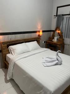 Ngurah Rai International AirportD nux House的一张白色的大床,上面有毛巾