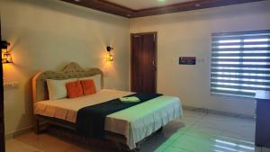 a bedroom with a bed with orange pillows and a window at Bell Farms and Resorts in Munroe Island