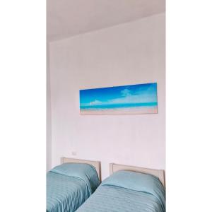 two beds in a room with a picture of the beach at Affittacamere Les chambres in Chiavari