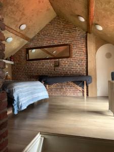 a room with a bed in a brick wall at Althuizenhof - Leem in Doenrade