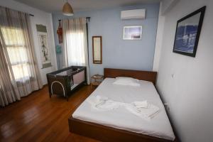 Schlafzimmer mit einem Bett mit weißer Bettwäsche und einem TV in der Unterkunft Villa Ostria - by Rentals Pro Nea Moudania in Nea Moudania