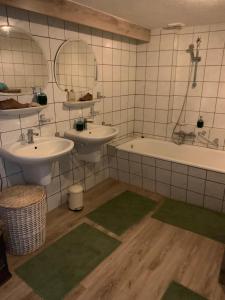 a bathroom with two sinks and a bath tub at Althuizenhof - Leem in Doenrade