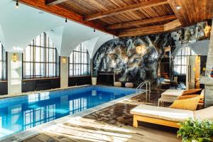 a pool in a hotel room with a large wall of windows at Дом у озера in Borovoye