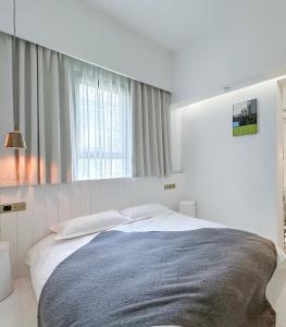 a white bedroom with a large bed in front of a window at Suzhou Unique Space Design Art Hotel in Suzhou +86 photos