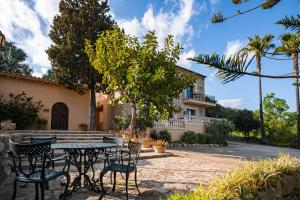 Un patio con una mesa y sillas frente a una casa. en Son Simo D'alt, en Alcudia