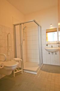 a bathroom with a shower and a toilet and a sink at Pension bei der Marienkirche in Mühlhausen