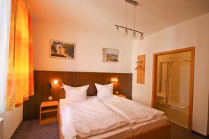 a bedroom with a bed and a bathroom at Pension bei der Marienkirche in Mühlhausen +21 photos