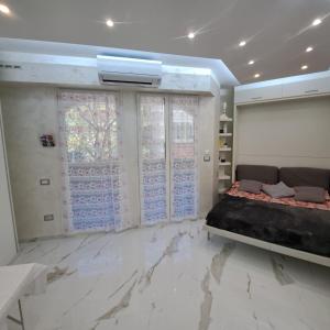 a bedroom with a bed and marble floors at Sharon Apartment in Victoria Beach in Menton