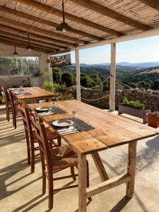 a wooden table and chairs on a patio at Agriturismo La Tana di Lu Maccioni in Santa Teresa Gallura