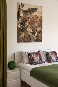 a bedroom with a bed with a painting on the wall at Przytulny apartament KOLEJOVA 13 - idealny jako baza wypadowa in Nowy Targ