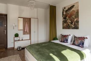 a bedroom with a large bed with a green blanket at Przytulny apartament KOLEJOVA 13 - idealny jako baza wypadowa in Nowy Targ