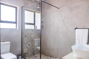 a bathroom with a shower and a toilet and a sink at Die Watergat in Marloth Park +17 photos