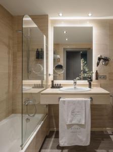 a bathroom with a sink and a shower and a tub at Hotel Antik San Sebastián in Donostia-San Sebastián