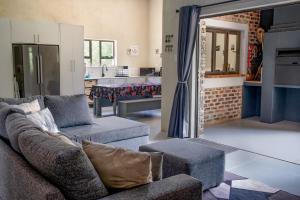 a living room with a couch and a kitchen at Die Watergat in Marloth Park