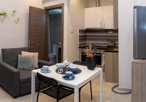a kitchen and living room with a white table and chairs at Xenia_Apartments A5 in Kozani