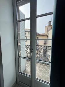 an open window with a view of a building at Maison Pépinière Royat in Royat