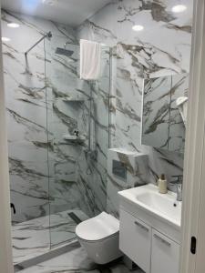 a bathroom with a shower and a toilet and a sink at VILLA Kachreti Ambassadori Golf Resort in Kachretʼi