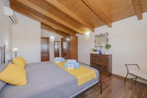 a bedroom with a bed with yellow pillows and a mirror at Villa Las Comas de Dalt in Alcudia +66 photos