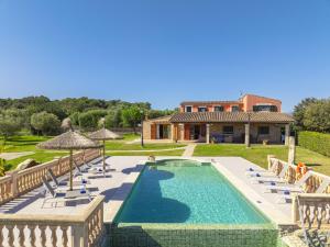 a villa with a swimming pool and chairs and a house at Villa Las Comas de Dalt in Alcudia
