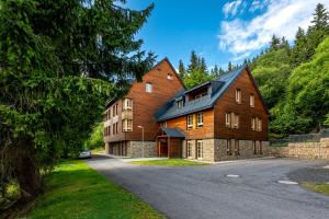 a large wooden house with a driveway at Horní Mísečky - I3 Pohodlný a teplý apartmán u sjezdovky in Horni Misecky