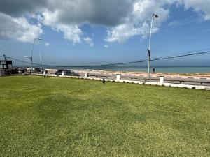 ein Grasfeld neben einem Strand mit Straßenbeleuchtung in der Unterkunft Appartement à Dar bouaaza in Tamaris