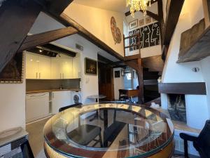 纳沙泰尔Appartement hyper centre de Neuchâtel tout confort的一间带玻璃桌的用餐室和一间厨房