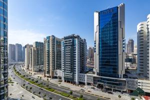 miasto z wysokimi budynkami i autostradą w obiekcie Cozy Studio with City Views at Bayz by Danube by BMS w Dubaju