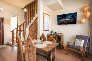 a dining room with a wooden table and chairs at Clove Island Essence & Spa Boutique in Matemwe +58 photos