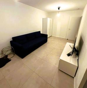 a living room with a blue couch and a table at Cozy studio avec balcon aux portes de Genève in Ambilly +4 photos