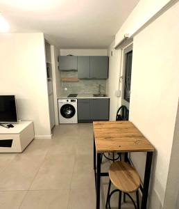 a small kitchen with a table and a stove at Cozy studio avec balcon aux portes de Genève in Ambilly