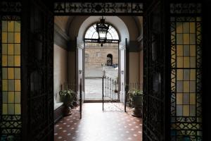 un accès à un bâtiment avec une porte ouverte dans l'établissement Pitti13, à Florence