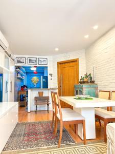 uma cozinha com uma mesa branca e cadeiras de madeira em 500m da praia - wifi e sofisticação no Leblon no Rio de Janeiro