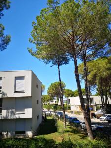 a building with trees in front of a parking lot at Gjiri i Lalzit - San Pietro - Leta's Apartments with Garden in Lalzit Bay
