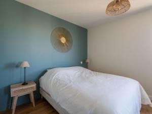 a bedroom with a white bed and a blue wall at Maison neuve proche océan, terrasse, parking, 8 pers - FR-1-319-585 in Biscarrosse