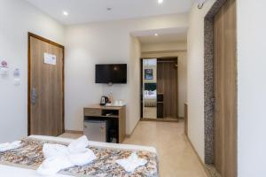 a hotel room with a bed and a tv at Hotel Flora in Male City