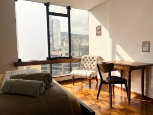 a bedroom with a desk and a table and a chair at Soleado departamento con vistas hermosas Sopocachi in La Paz