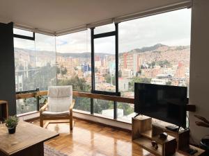 a living room with a large window view of a city at Soleado departamento con vistas hermosas Sopocachi in La Paz