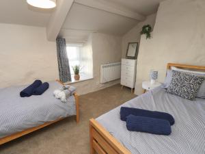 Un dormitorio con dos camas y una ventana. en Hafod, en Pwllheli