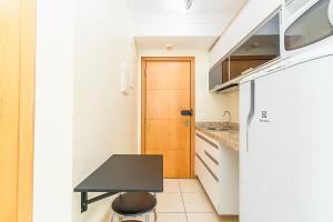 a kitchen with a black table and a wooden door at Saint Moritz Hotel em Brasília 91641 in Brasilia