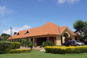 ein Haus mit orangefarbenem Kacheldach in der Unterkunft Peniel Beach Hotel in Entebbe