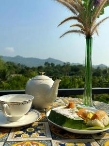 una mesa con una tetera, un tazón y una tetera en Uma Valley Homestay - Nature Oasis near Hay Yai, en Ban Wang Ching